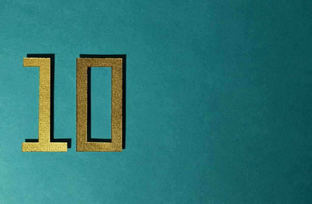 A gold number 10 on a teal background
