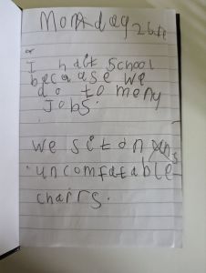 A picture of child's writing stating we sit on uncomfortable chairs