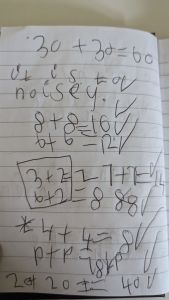 A picture of a child's writing with lots of maths sums
