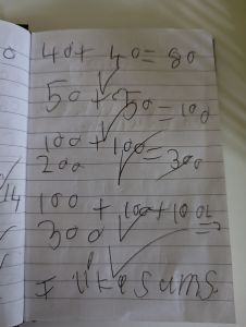 A picture of child's writing with sums and saying I like sums