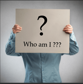 A person holding a sign up with a question mark on and the words who am i